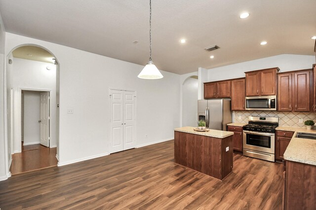 kitchen with a center island, dark wood-type flooring, decorative light fixtures, decorative backsplash, and appliances with stainless steel finishes