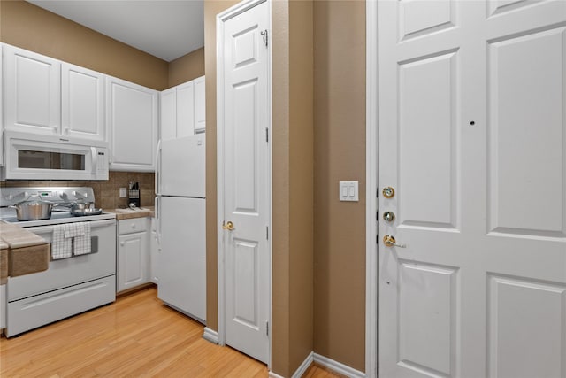 kitchen with white cabinets, decorative backsplash, white appliances, and light wood-type flooring