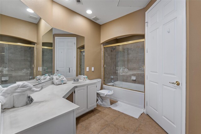 full bathroom with shower / bath combination with glass door, tile patterned floors, vanity, and toilet