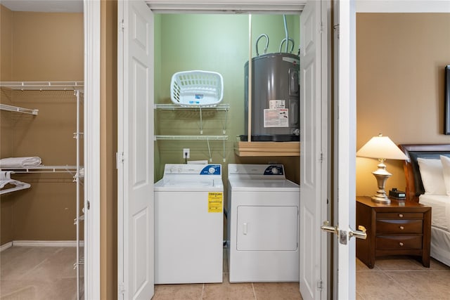 washroom featuring electric water heater, light tile patterned flooring, and independent washer and dryer