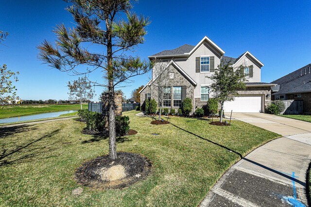 view of front of property featuring a garage, a water view, and a front yard