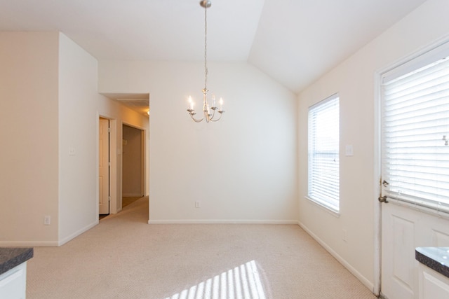 unfurnished dining area featuring light carpet, lofted ceiling, and a notable chandelier