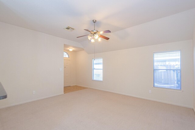 carpeted empty room featuring ceiling fan and vaulted ceiling