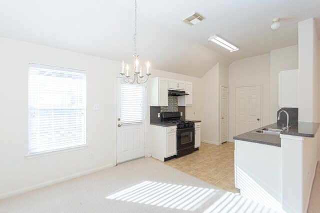 kitchen featuring sink, black range with gas stovetop, vaulted ceiling, decorative light fixtures, and white cabinets