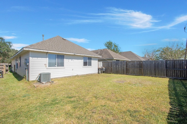 rear view of property with a lawn and central air condition unit