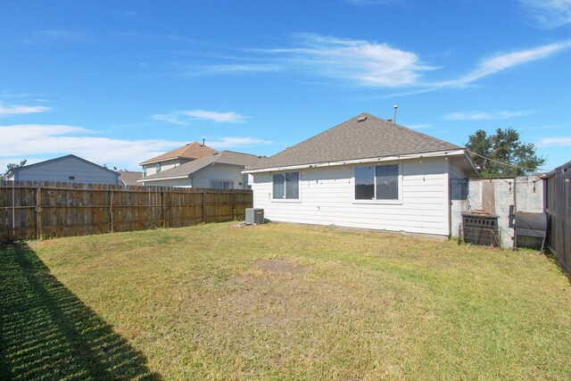 back of property featuring central AC unit and a yard