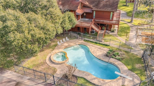 view of pool with a yard, a diving board, a wooden deck, a patio area, and an in ground hot tub