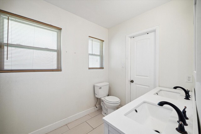 bathroom featuring tile patterned flooring, vanity, and toilet