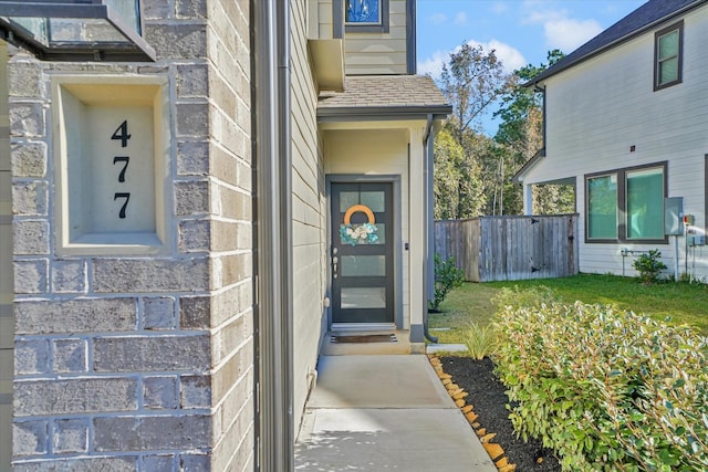 property entrance with a lawn