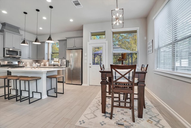 dining area featuring light hardwood / wood-style floors, an inviting chandelier, plenty of natural light, and sink