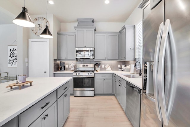 kitchen with pendant lighting, stainless steel appliances, gray cabinetry, and sink