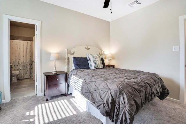 carpeted bedroom with ceiling fan and ensuite bath