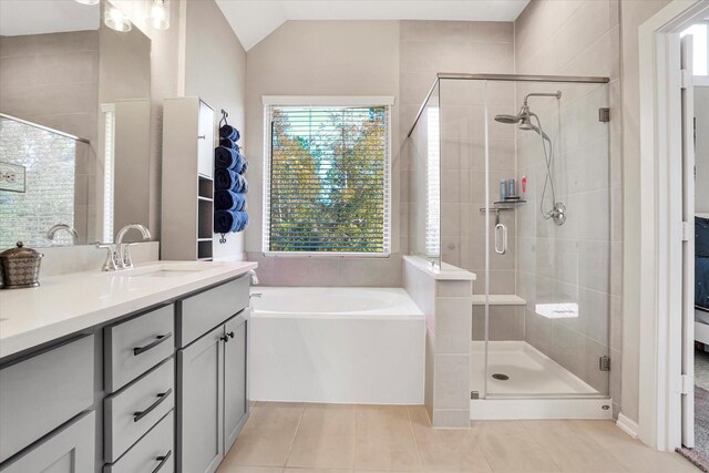 bathroom featuring tile patterned floors, vanity, vaulted ceiling, and independent shower and bath