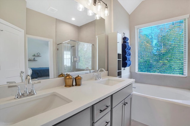 bathroom with plenty of natural light, vanity, independent shower and bath, and vaulted ceiling