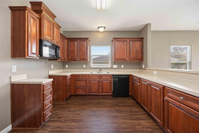 kitchen with black appliances, dark hardwood / wood-style flooring, kitchen peninsula, and sink