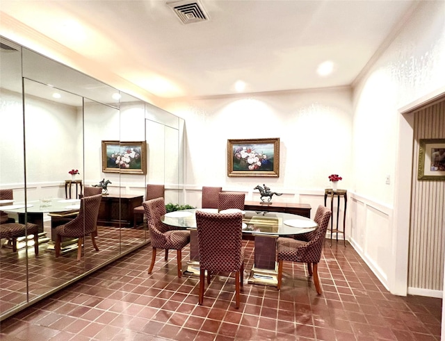 tiled dining space featuring crown molding