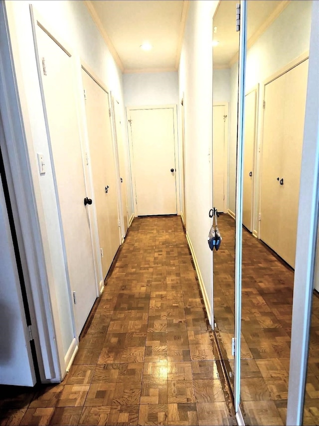 corridor with crown molding and dark parquet floors