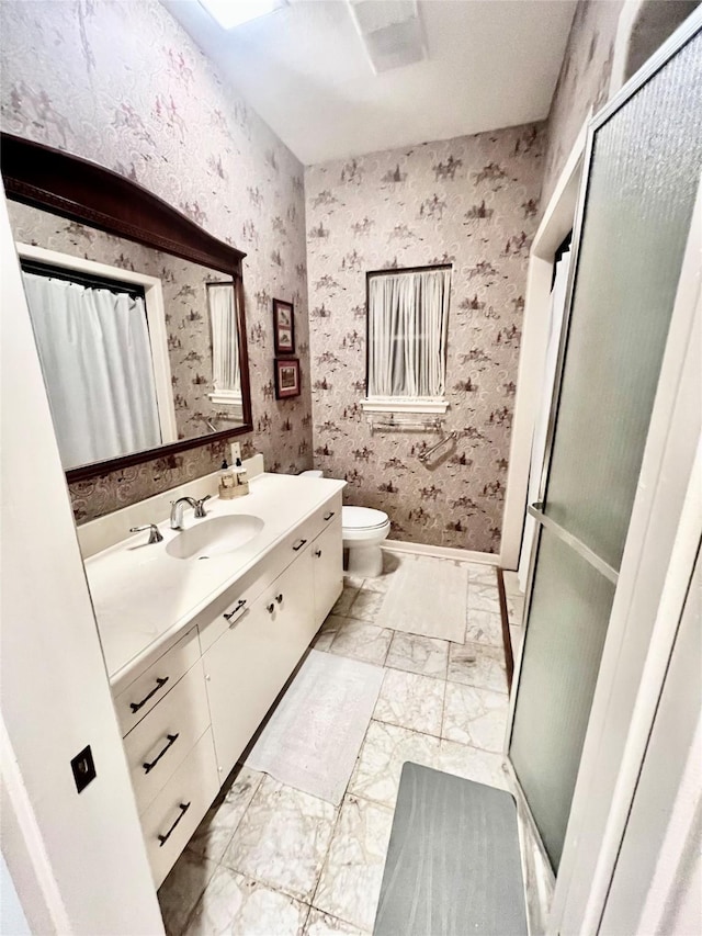 bathroom featuring vanity, toilet, and a shower with shower door