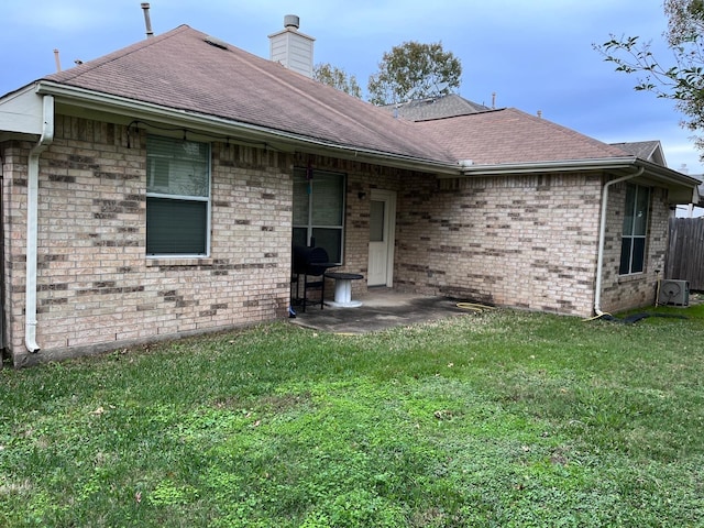 back of property featuring a lawn and a patio