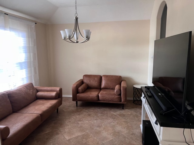 living room with a healthy amount of sunlight, vaulted ceiling, and a notable chandelier