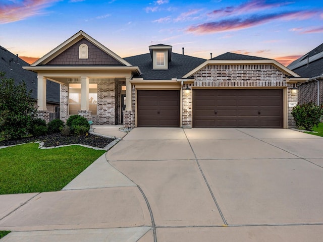 view of front of house with a lawn, a porch, and a garage