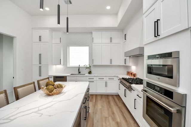 kitchen with a breakfast bar area, pendant lighting, and white cabinets