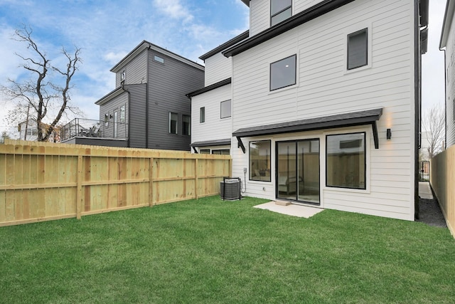 rear view of house with a yard and central air condition unit