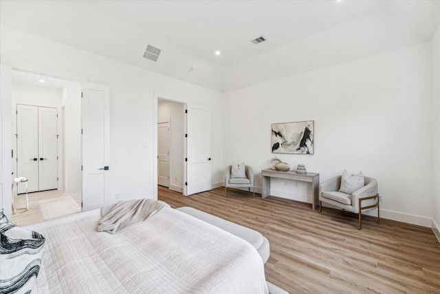 bedroom featuring light hardwood / wood-style flooring and lofted ceiling