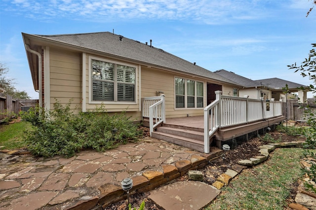 back of property with a deck and a patio area