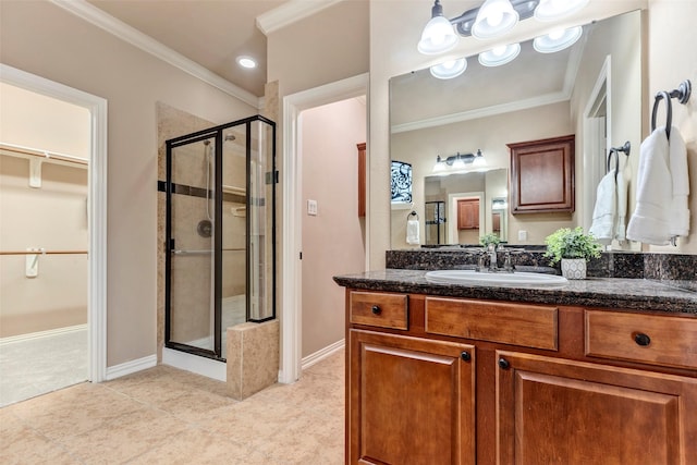 bathroom featuring tile patterned floors, ornamental molding, a shower with shower door, and vanity