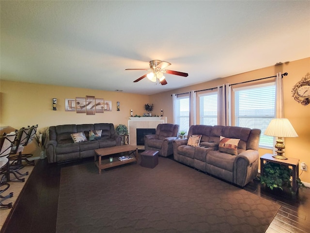 living room featuring a fireplace, wood-type flooring, and ceiling fan