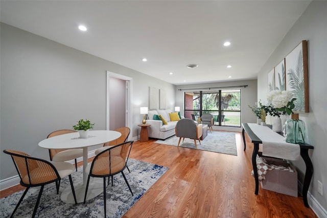 dining area featuring light wood finished floors, recessed lighting, and baseboards