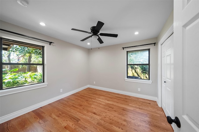 spare room with plenty of natural light, ceiling fan, and light hardwood / wood-style flooring