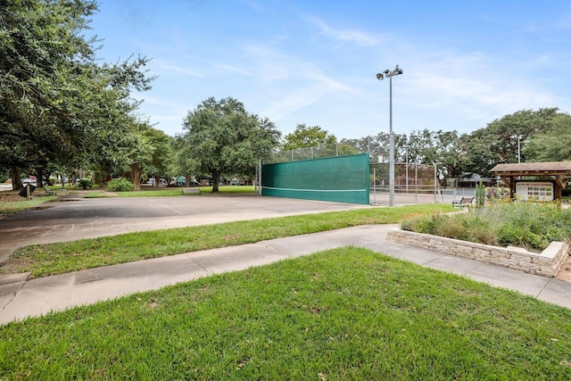 view of property's community with fence and a lawn