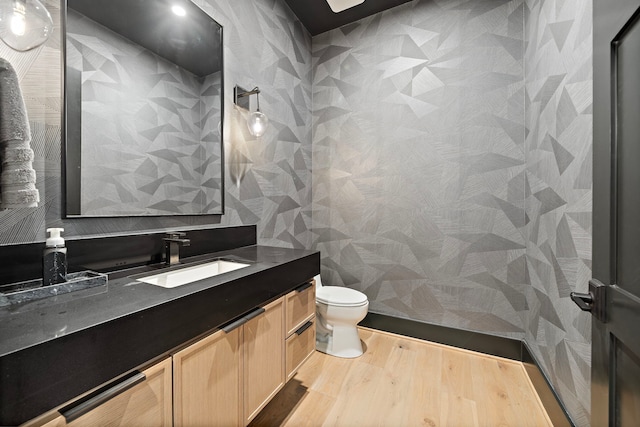 bathroom with hardwood / wood-style floors, vanity, and toilet