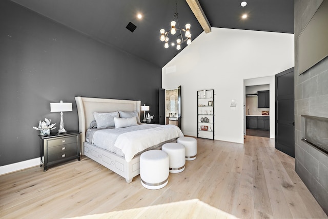 bedroom featuring high vaulted ceiling, an inviting chandelier, light hardwood / wood-style floors, a fireplace, and beam ceiling