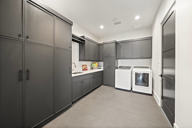 kitchen with gray cabinetry, sink, and independent washer and dryer