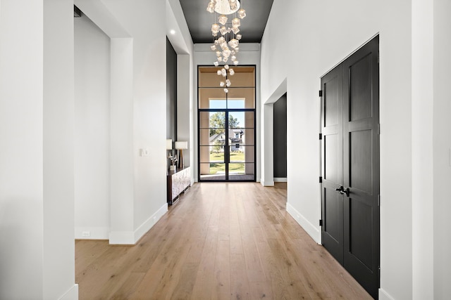 entryway featuring light hardwood / wood-style flooring and a chandelier