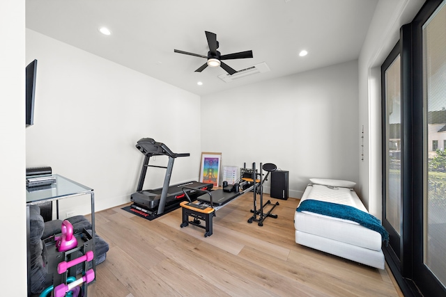 exercise area with ceiling fan and light wood-type flooring