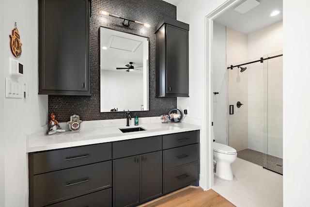 bathroom with ceiling fan, toilet, decorative backsplash, vanity, and hardwood / wood-style flooring