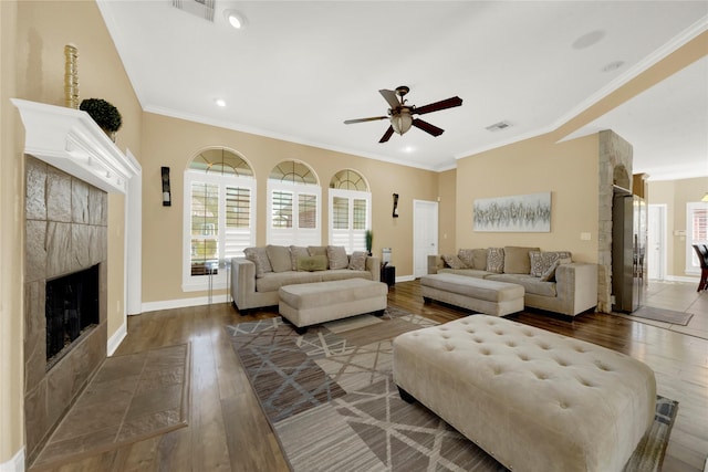 living room featuring crown molding, ceiling fan, dark hardwood / wood-style flooring, and a fireplace