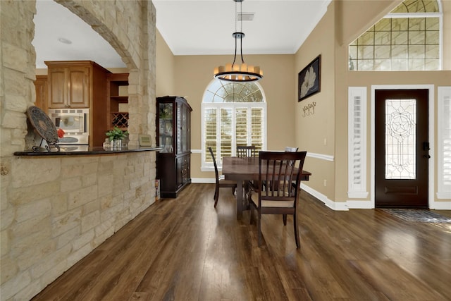 dining room with dark hardwood / wood-style flooring, a chandelier, and ornamental molding