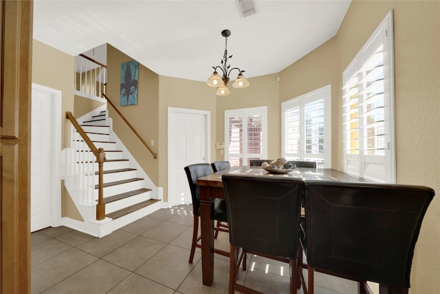 dining room featuring tile patterned flooring and a notable chandelier