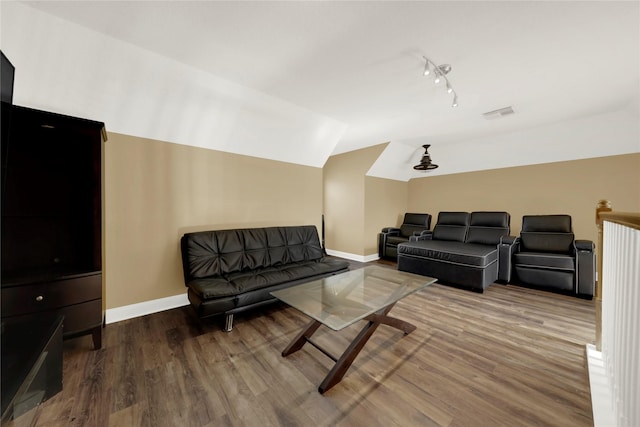 cinema with hardwood / wood-style flooring and lofted ceiling