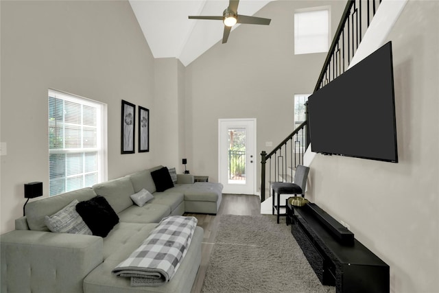 living room with hardwood / wood-style flooring, high vaulted ceiling, and ceiling fan