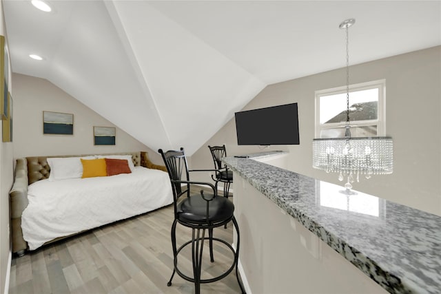 bedroom with lofted ceiling and light hardwood / wood-style flooring