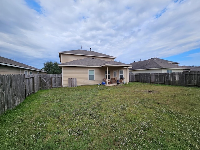 back of house featuring a patio area and a yard