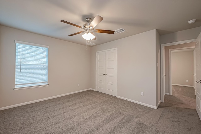 unfurnished bedroom with carpet, ceiling fan, and a closet