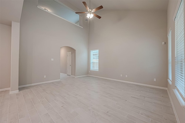 spare room featuring ceiling fan, high vaulted ceiling, and light hardwood / wood-style flooring