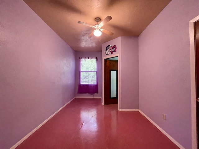 empty room with ceiling fan, concrete floors, and a textured ceiling